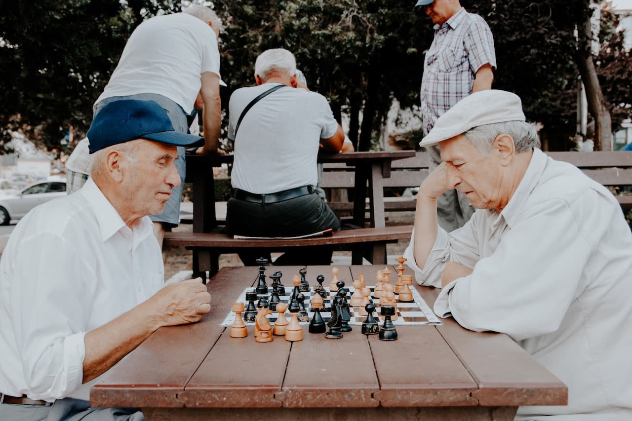 two white old men playing chess