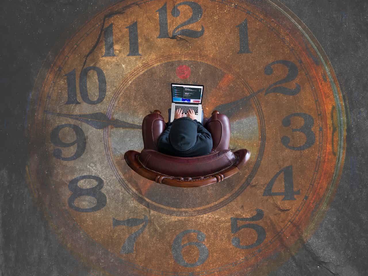 A man using a computer in the middle of a clock